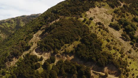 Hills-and-forest-drone-footage-with-roads-going-up-hill