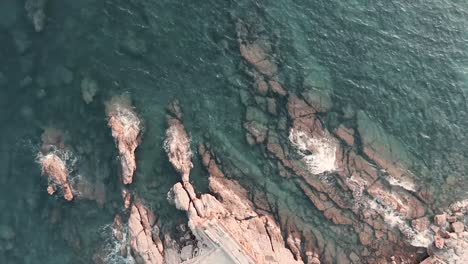 Clear-cool-waves-rolling-on-the-rocky-shores-of-Genoa,-Italy--aerial