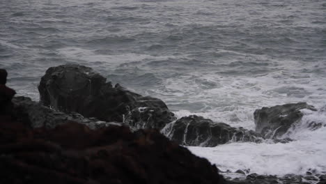 Wellen-Spritzen-Gegen-Felsen-Am-Isländischen-Schwarzen-Sandstrand