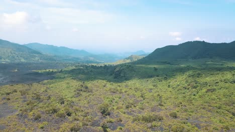 Drohnenluftaufnahme-Einer-Sandigen-Landschaft-Mit-Grünen-Bergen-In-Der-Nähe-Des-Vulkans-Pacaya-In-Guatemala