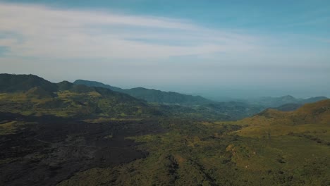 Drohnen-Luftaufnahme-Einer-Landschaft-Mit-Grünen-Bergen-Und-Vulkansand-In-Der-Nähe-Des-Vulkans-Pacaya-In-Guatemala