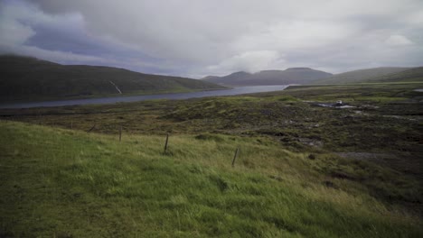 Green-fields-and-Sorvagsvatn-Lake-On-Cliffs-Of-Vagar-Island-during-cloudy-day