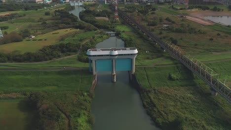 Vista-Aérea-De-La-Compuerta-De-Inundación-Del-Río-Arakawa-Con-Ferrocarril-Elevado-En-Saitama,-Japón---Tiro-Poi