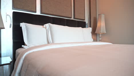 Medium-close-pan-across-a-perfectly-made-hotel-suite-bed