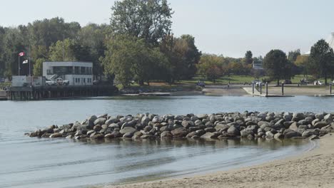Stone-pier-next-to-small-beach-with-small-waves