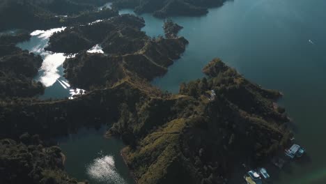 Drone-aerial-view-of-the-lake-and-green-islands-during-daytime-at-El-Peñón-in-Guatapé,-Colombia