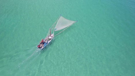 Aerial-shot-of-a-traditional-shrimp-fisherman-on-small-wooden-boat-in-Thailand
