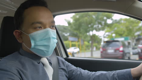 Mid-Shot-Of-A-Business-Man-Wearing-A-Face-Mask-While-Driving-Around-The-City
