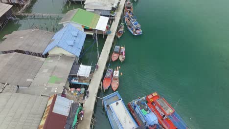 Aerial-drone-dolly-shot-of-a-traditional-Thai-fishing-village-with-small-oil-slick-from-boats-in-Koh-Kood-,Thailand