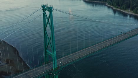Atemberaubende-Drohnen-Luftaufnahme-Der-Lions-Gate-Bridge,-Die-Nach-Unten-Geneigt-Ist,-Enthüllt-Die-Skyline-Von-Vancouver