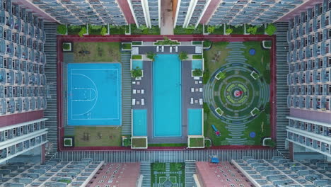 Pull-Out-Circular-Top-Shot-Of-The-Garden,-Pool-And-Court-Of-A-Condominium-In-Manila