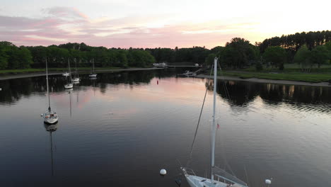 Aerial-Drone-Footage-at-Saco-River-overlooking-parked-yatch-and-fishing-boat-at-sunset-in-Saco-Bay,-Maine