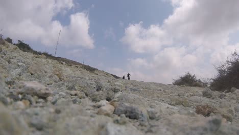 Low-angle-view-of-mountain-bikers-riding-downhill-towards-camera-on-a-rocky-mountain-in-Akamas,-Cyprus