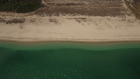 Fly-By-Drone-Footage-showing-beachfront-and-emerald-green-waves-at-Cabo-San-Lucas,-Mexico