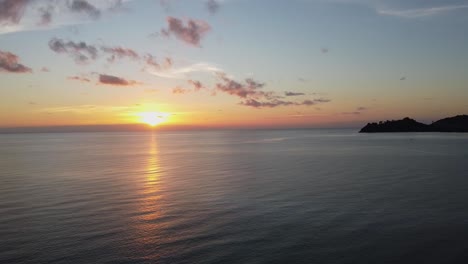 Luftaufnahme:-Drohne-Fliegt-Hoch-über-Den-Küstenwellen-Bei-Malerischem-Sonnenuntergang-Mit-Inseln-Im-Hintergrund