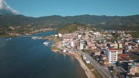 Drone-aerial-town-and-the-lake-in-El-Peñón-in-Guatapé,-Colombia
