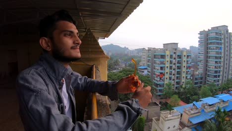 teenage-boy-enjoying-view-from-building-terrace-smiling-happy-indian