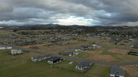 Fly-over-aerial-drone-footage-overlooking-sprawling-surburban-houses-at-Te-Anau,-New-Zealand
