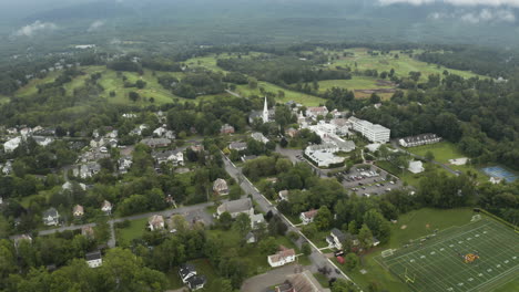 Aerial-drone-pan-down-footage-of-Manchester,-Vermont,-USA-from-the-clouds