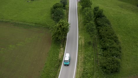 Aerial-of-Old-Car-Driving-on-Empty-Street-on-its-Europe-Roadtrip