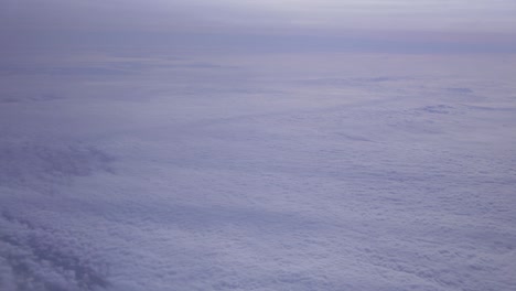 Aufnahme-Aus-Dem-Flugzeugfenster-Mit-Viel-Blauem-Himmel-Und-Einigen-Wolken