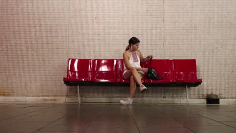 Girl-Sitting-Down-At-The-Subway-On-Her-Phone