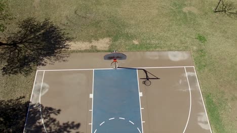 Drone-footage-of-Scottsdale-city-park,-basketball-court-pull-back-from-the-hoop-to-the