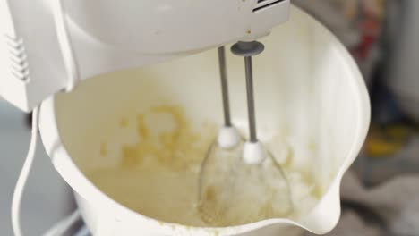 Mixing-pancakes-in-a-white-bowl-with-an-electronic-mixer