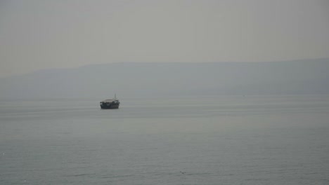 A-reproduction-of-a-2,000-year-old-fishing-boat-slowly-crossing-the-Sea-of-Galilee-in-Israel