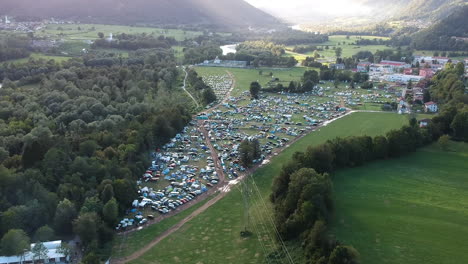 Aerial-drone-shot-of-a-camping-ground-at-a-music-festival-in-a-green-and-lush-mountainous-area