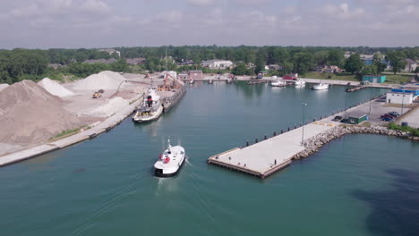 Aerial-View-Ferry-Boat-Arriving-In-The-Terminal-With-Barge-Unloading-Gravel-On-Gravel-Pit-Near-Kingsville-In-Ontario,-Canada
