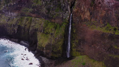 Luftaufnahme-Eines-Spektakulären-Wasserfalls,-Der-Die-Kühnen-Klippen-Von-Madeira-Hinunter-In-Den-Schäumenden-Atlantik-Führt