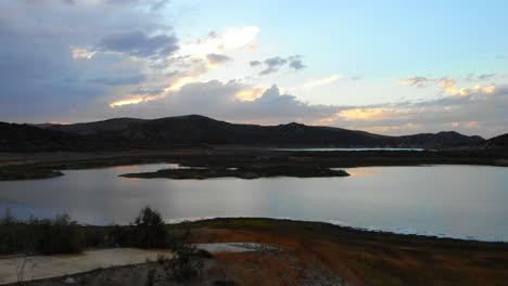 Aerial-drone-fly-be-wide-of-dried-up-Irvine-Lake-in-Southern-California-at-beautiful-sunset--lake-is-almost-empty-due-to-drought