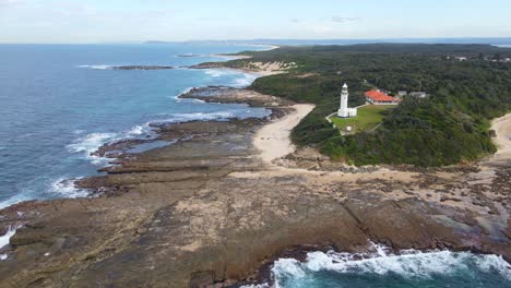Aerial-View-Of-Headland-Lighthouse-At-Norah-Head-With-Scenic-Beach-And-Ocean-Views---Historical-Lighthouse-At-Norah-Head,-NSW,-Australia