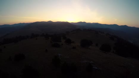 Flying-a-drone-on-top-of-a-hill-with-the-view-of-the-mountains-during-the-sunrise