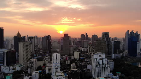 Aerial-Pullback-view-of-Bangkok's-Skyscrapers-at-Sunrise