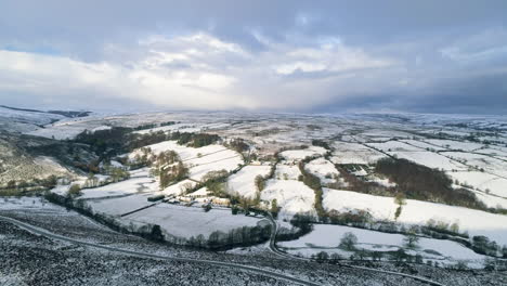 North-York-Moors-Snow-Scene-Drone-Flight,-Castleton,-Rosedale,-Flight-over-Westerdale-with-downwards-pan,-Winter-cold-and-moody-clouds,-Phantom-4,-Clip-6