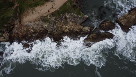 Waves-crashing-against-the-Northumberland-coast---aerial-stationary-shot
