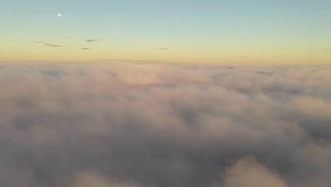 Vista-Aérea-De-Drones-De-Nubes-En-Movimiento-Y-Luna-Sobre-El-Horizonte