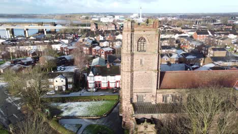 Aerial-right-pan-view-industrial-small-town-frosty-church-rooftops-neighbourhood-North-West-England