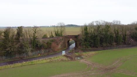 Drone-moving-towards-a-railway-bridge-in-the-countryside-in-a-Kent-village