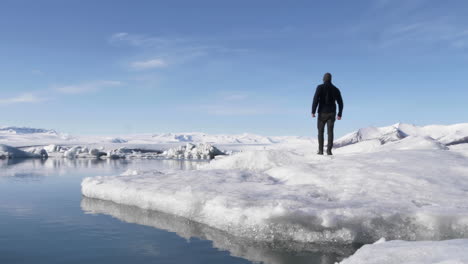 Hombre-Joven-Caminando-Témpano-De-Hielo-En-La-Hermosa-Laguna-Glacial-En-Islandia-En-Cámara-Lenta