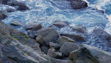 Splashing-Waves-Through-Big-Rocks-In-Coastal-Cliff-During-Summer
