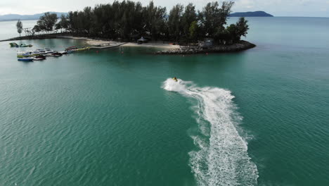 Luftaufnahme-Eines-Gelben-Jet-Skis,-Der-Schnell-Auf-Einer-Kleinen-Tropischen-Insel-In-Malaysia-Ankommt