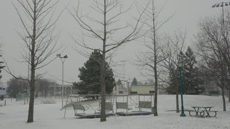 Blattlose-Bäume-Mit-Leerem-Parkbank-Picknicktisch-Im-Verschneiten-Winter