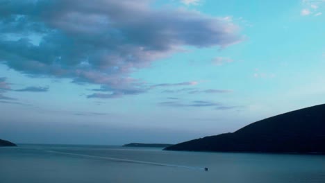 Ein-Einsames-Boot,-Das-Im-Sonnenuntergang-In-Eine-Wunderschöne-Bucht-Segelt