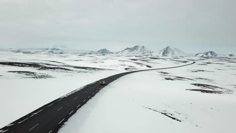 Aerial-View-of-Land-Rover-driving-on-empty-street-in-cold-Iceland-in-winter-scenery