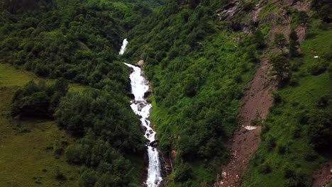 Aerial-view-of-Walcherfall-waterfall,-Ferleiten,-Austria,-flowing-down-through-a-mountain-forest