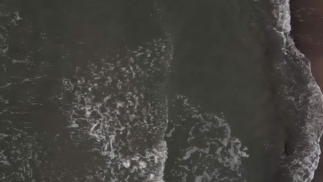 Luftaufnahme-Von-Wellen,-Die-Im-Winter-In-Den-Sandstrand-Von-Ustka-Schlagen