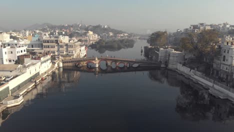 4k-aerial-footage-of-bridges-spanning-a-water-channel-of-the-city-of-Udaipur,-India